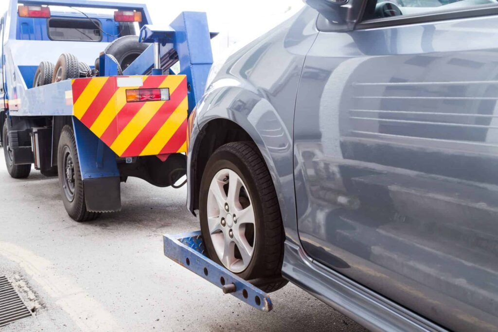 Tow truck towing a car that is not worth fixing.